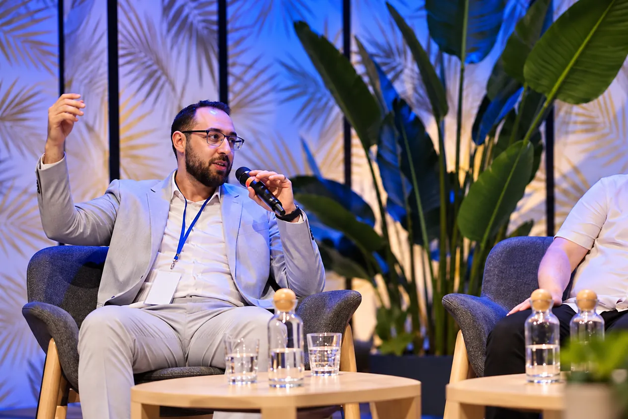 Hosam ASSAL prend la parole, micro en main, lors d'une table ronde