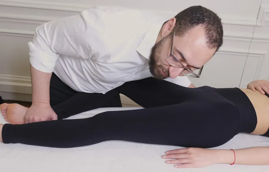 Hosam ASSAL mobilise la jambe d'une patiente allongée sur la table de soin
