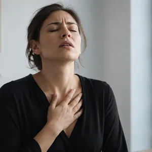 Femme les yeux fermés, la main sur la poitrine, qui cherche son souffle