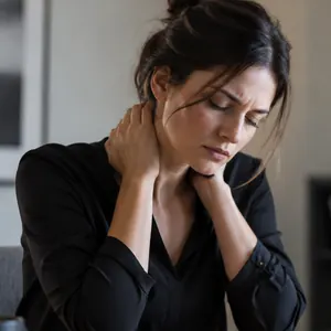 Femme à son bureau, les deux mains sur la nuque